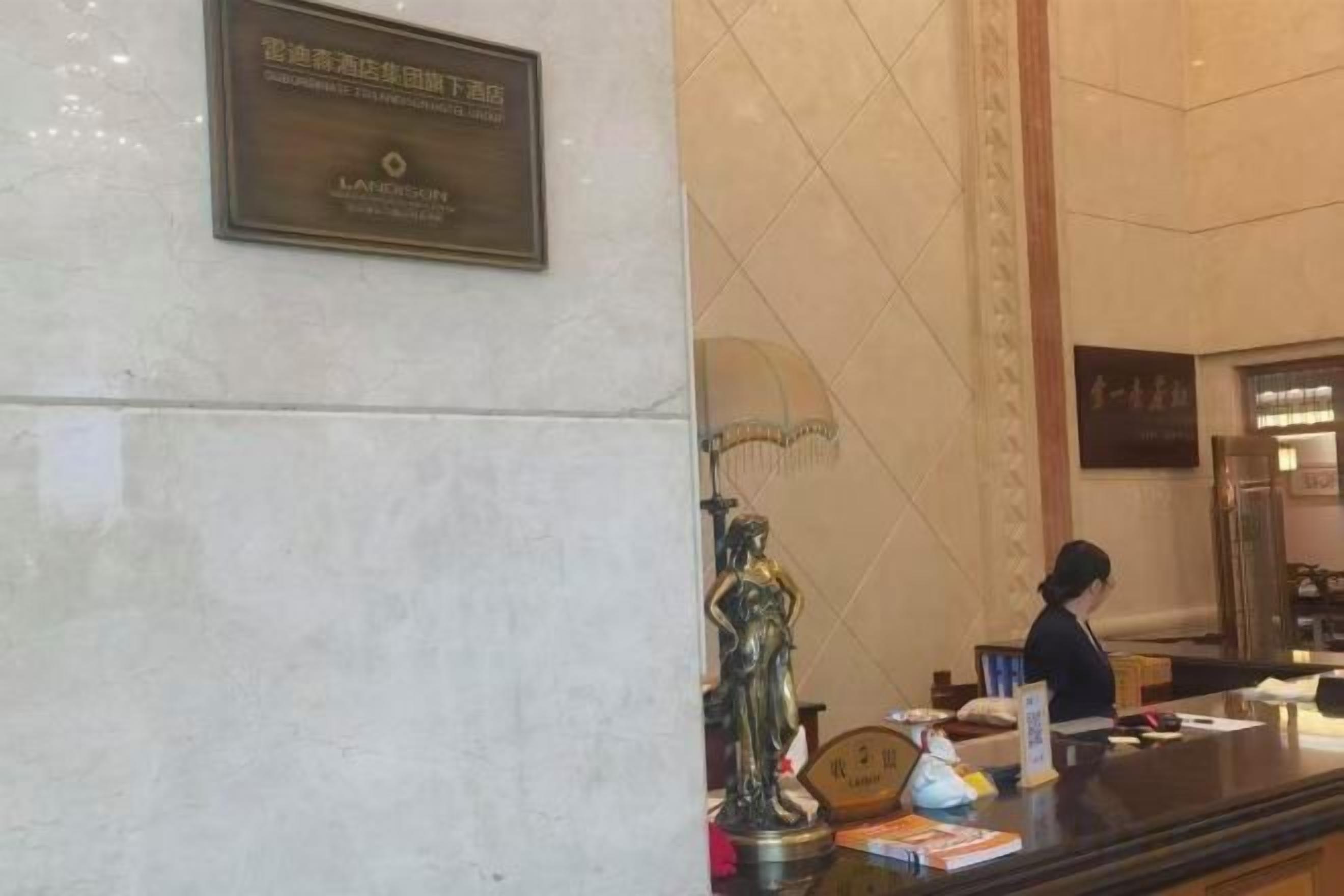A reception desk with a plaque, a statue, and a counter with various items.