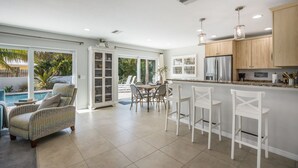 Eine geräumige Küche mit Essbereich, einem Pool und einer überdachten Terrasse.