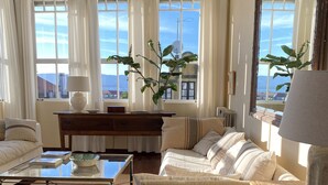 A spacious living room with a large window, a wooden coffee table, a sofa, and a side table. - SEÑORIAL HOUSE ON THE COAST WITH WONDERFUL PORCH (Villagarcía de Arosa)