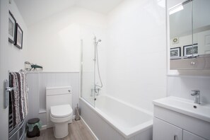 Une salle de bain avec des toilettes, une douche et un lavabo.