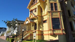 A large, yellow Victorian-style building with a prominent staircase and multiple windows. - Victorian Mansion at Carter House Inns (Eureka)