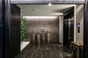 A modern elevator interior with a marble floor, a wall-mounted plant, and a digital control panel. - Junlin Banshan Hotel (Chenzhou)