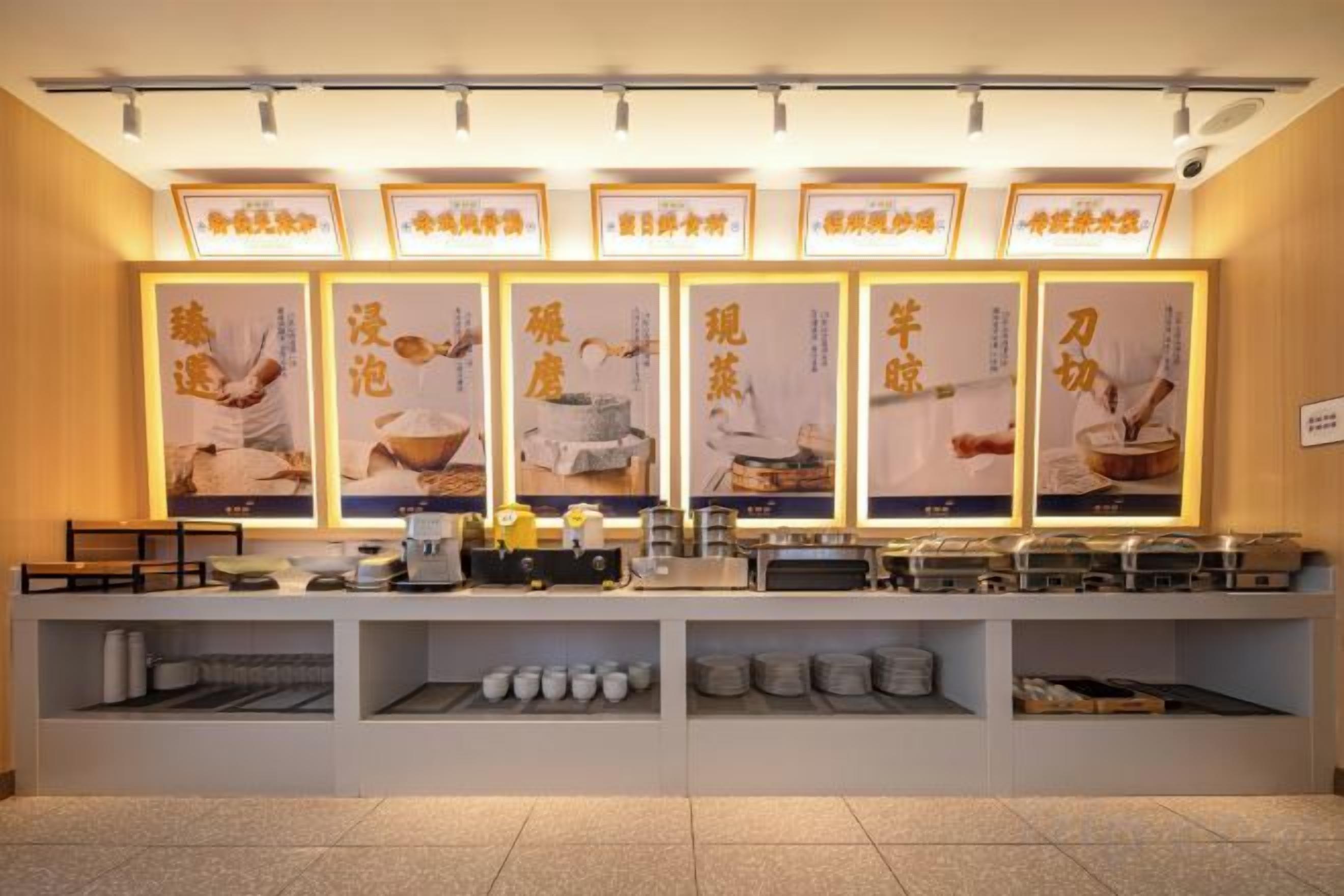 A buffet setup with multiple food stations, illuminated signage, and a clean, organized layout.
