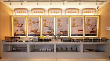 A buffet setup with multiple food stations, illuminated signage, and a clean, organized layout.