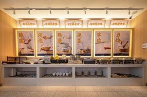A buffet setup with multiple food stations, illuminated signage, and a clean, organized layout.