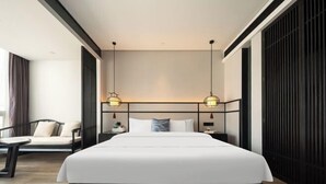 A modern hotel room with a large bed, bedside tables, a sofa, and pendant lighting. - Junlin Banshan Hotel (Chenzhou)