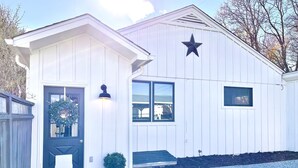 A white building with a black door, a star decoration, and a potted plant. - Updated, 2 Bedroom Cottage, close to Boulder (Lafayette)