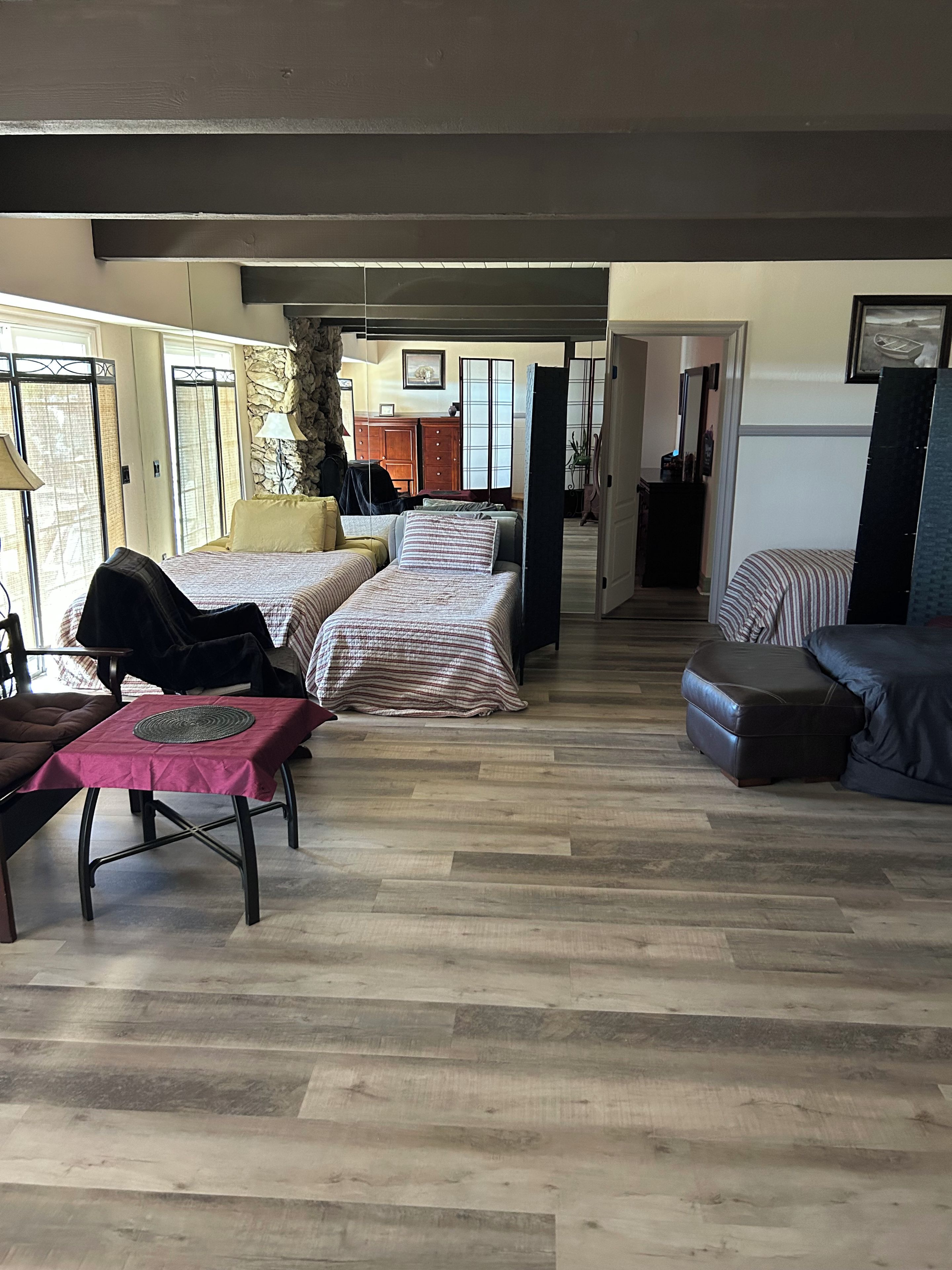 A spacious room with a large bed, a sofa, and a dining table.