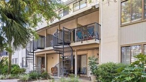 A multi-story building with a spiral staircase, outdoor seating, and a well-maintained garden. - Relaxcation! (Hilton Head Island)