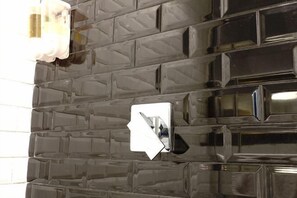 A wall with a textured, dark-colored surface and a reflective, metallic object that appears to be a light switch or control panel. - Fanpu Art Hotel (Jiaxing)