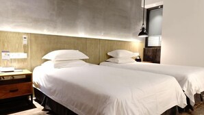 A hotel room with two beds, a wooden nightstand, a desk, and a lamp. - Fanpu Art Hotel (Jiaxing)