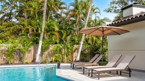 A swimming pool with lounge chairs and an umbrella, surrounded by lush greenery. - 5-3 1/2 Aventura-Heated Pool-Gas Grill-Coverd Patio (North Miami Beach)