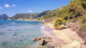 A coastal landscape with clear waters, a sandy beach, and a mountainous backdrop. - Ocean View - Luxury Villa Ethra (Corfu)
