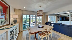 A modern kitchen with a dining area, large windows, and a view of the outdoors. - Luxury Condo with Outdoor Dining and Community Pool. (Ponte Vedra)