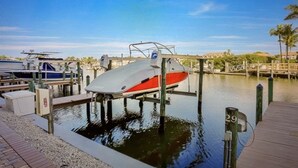 A marina with boats docked, a wooden dock, and a clear blue sky. - Vanderbilt Beach area with Bay views from Lanai. (Naples)