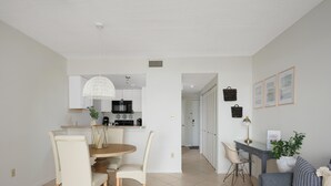 Un appartement moderne comprenant un coin repas, une cuisine et un salon.