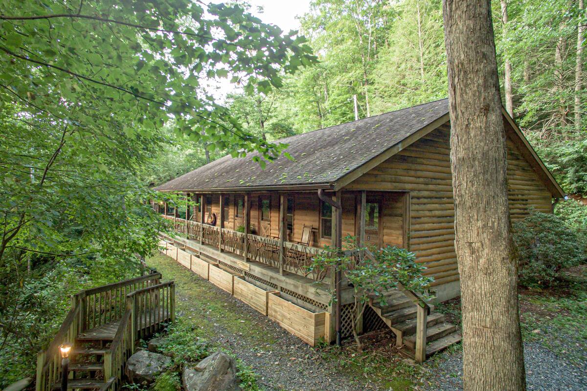 Eine Holzjagdhaus mit Veranda, Holzstufen und Geländer.