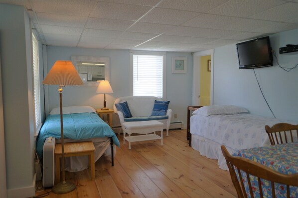 A room with a bed, a chair, a table, a lamp, and a television. - Short Sands View - Spacious Beach Home, Sleeps 18, Easy Walk to Short Sands Beach (York)