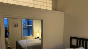 Ein Schlafzimmer mit zwei Betten, einem Nachttisch und einem Fenster.