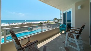 Een balkon met uitzicht op het strand en het zwembad.