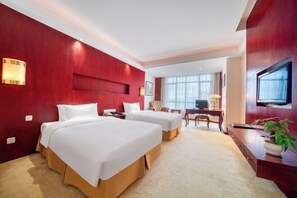 A hotel room with two beds, a desk, a chair, a television, and a plant. - Linhai Double-Dove Peace International Hotel (Linhai)