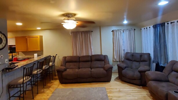 A living room with a sofa, armchairs, a coffee table, and a dining area with chairs and a table.