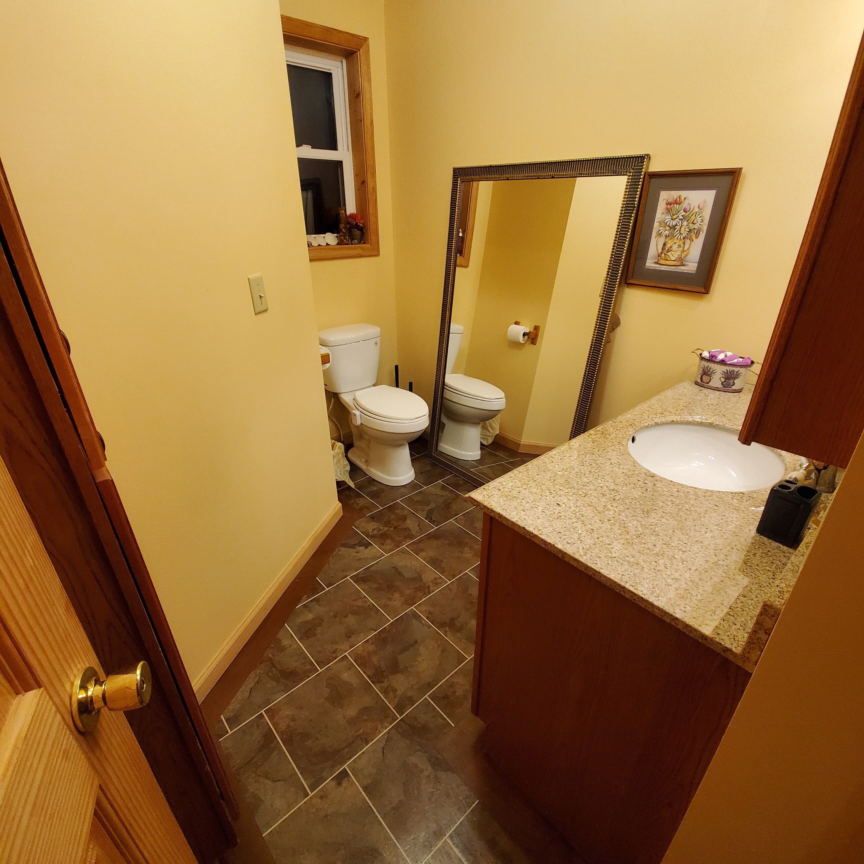 A small bathroom with a toilet, sink, and mirror.