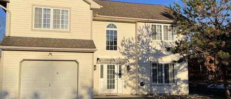 A two-story house with a garage, a covered entryway, and a small porch.