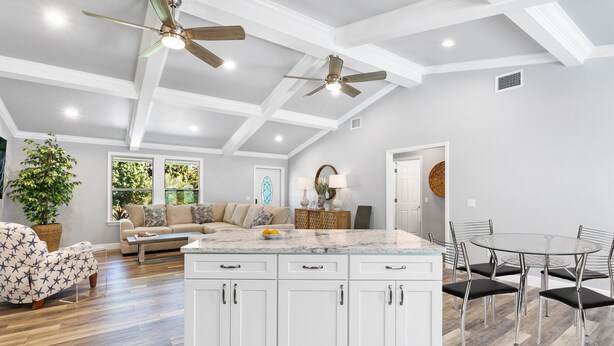 A spacious living area with a large island kitchen, wooden flooring, and ceiling fans. - New Construction- Hot Tub - 1.3m to Beach, 2 KING Beds. (Hobe Sound)