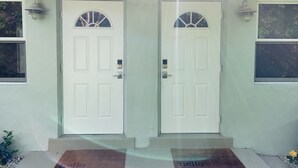 A house with two white doors, each with a small window above the door.
