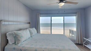 A bedroom with a bed, a ceiling fan, and a view of the beach. - Ocean's Edge | Pet-Friendly Oceanfront Home with Direct Beach Access (Ponte Vedra)