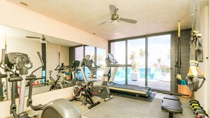 A gym with various exercise equipment, a treadmill, and a ceiling fan. - Sabor A Miel by Stella Rentals (Playa del Carmen)