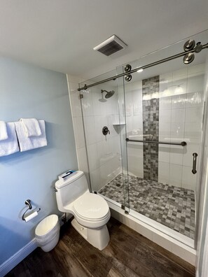 A modern bathroom with a glass-enclosed shower, a toilet, and a sink. - Spacious condo, great location in paradise! (Key Largo)