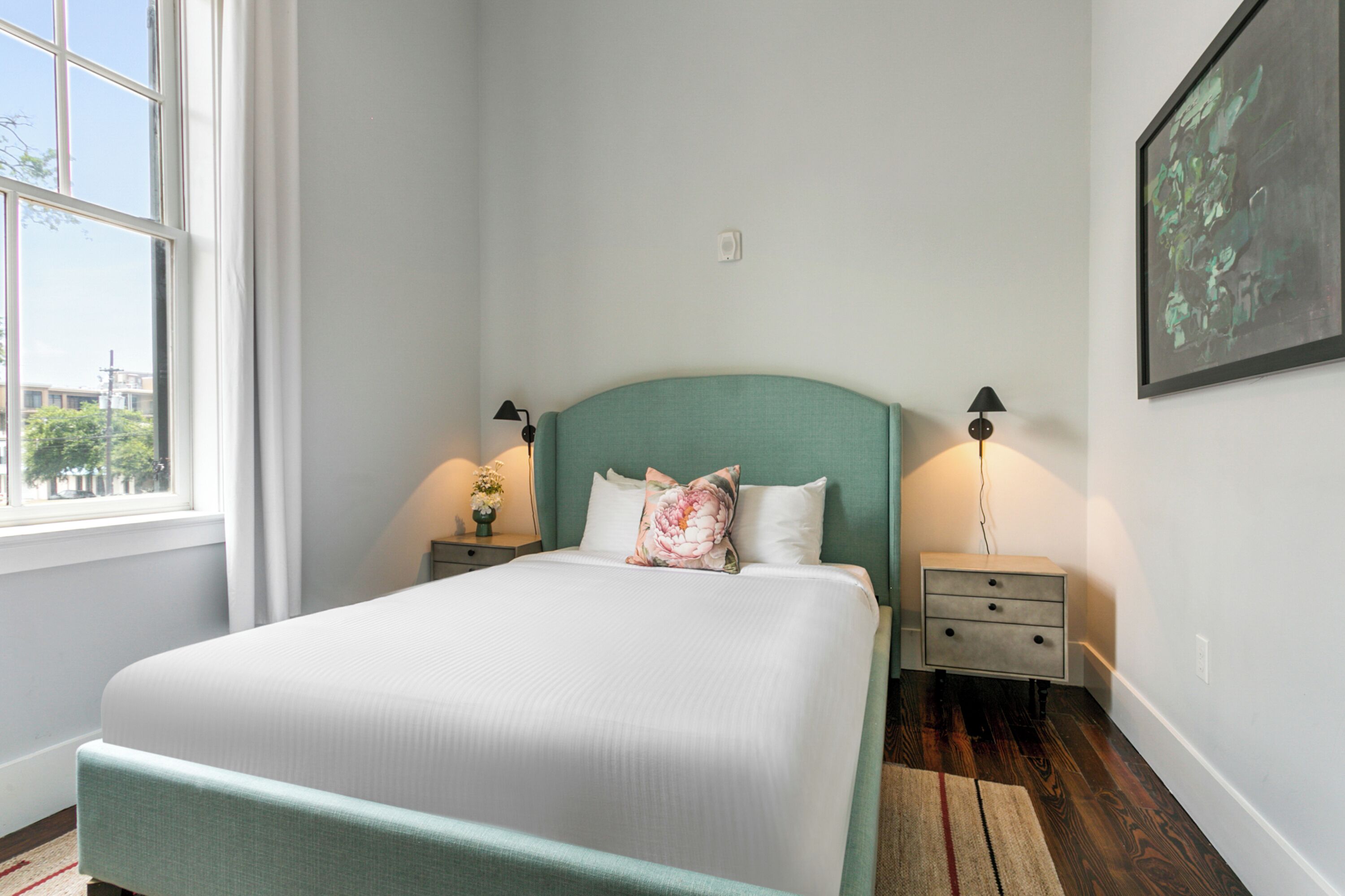 A neatly arranged bedroom with a bed, bedside tables, and a window.