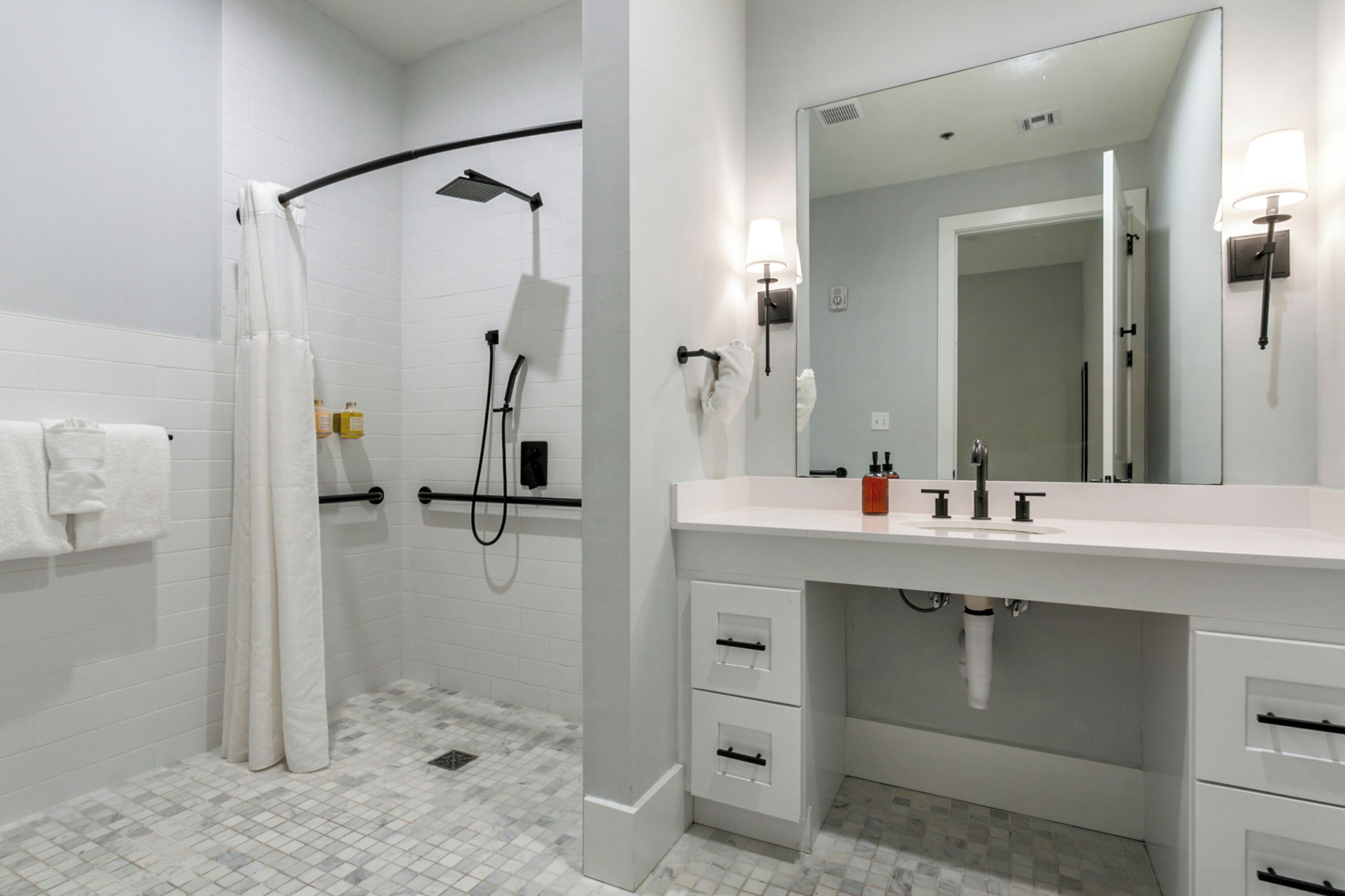 A modern bathroom with a shower, toilet, and sink.