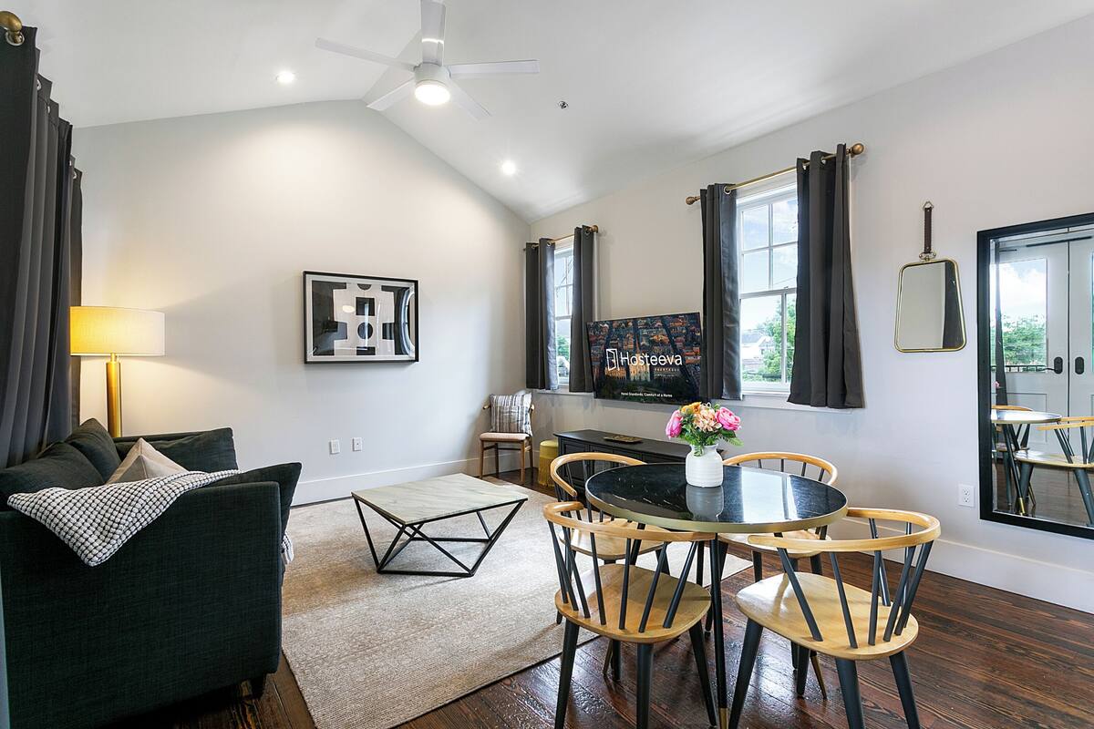 Ein modernes Wohnzimmer mit einer Couch, einem Couchtisch und einem an der Wand befestigten Fernseher.