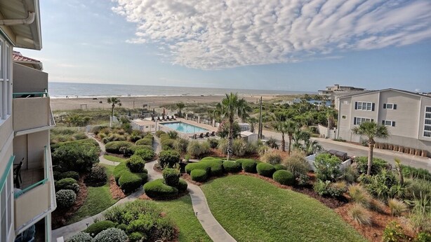 Un resort con piscina, jardines ajardinados y vistas a la playa.
