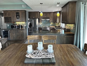A modern kitchen with wooden cabinets, stainless steel appliances, and a central island.