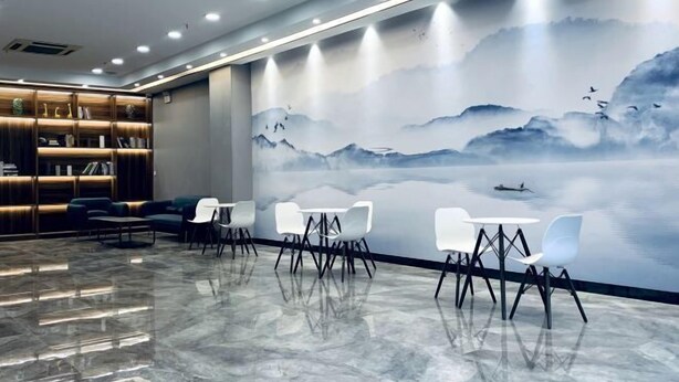 A modern interior with a seating area, a bookshelf, and a mural depicting a serene landscape. - Saijia Hotel (Rugao Rt Mart) (Rugao)