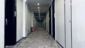 A long, narrow hallway with doors on both sides, a patterned floor, and recessed lighting on the ceiling. - Saijia Hotel (Rugao Rt Mart) (Rugao)