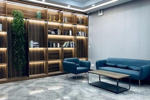 Un interior moderno con una estantería de madera, un sofá azul y una mesa de centro.
