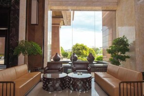 A lobby with leather sofas, round tables, and large vases. - Jade Intercontinental Hotel (Guangchang)