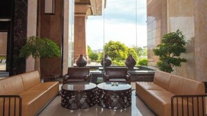 A lobby with leather sofas, a coffee table, and large vases.
