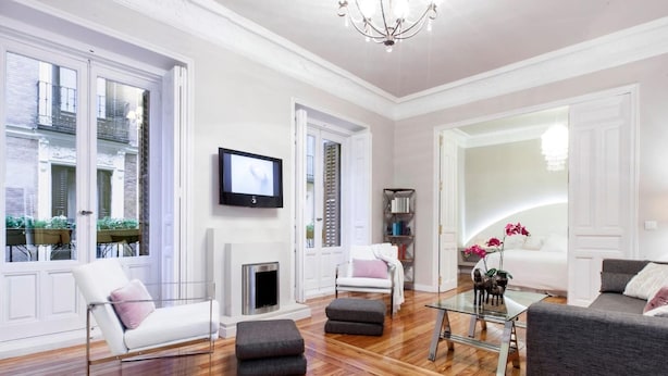 Ein geräumiges Wohnzimmer mit Kamin, Fernseher und einer gemütlichen Sitzecke mit Sofa und Sesseln.