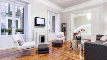 Un salon spacieux doté d’une cheminée, d’un téléviseur et d’un coin salon confortable avec un canapé et des fauteuils.