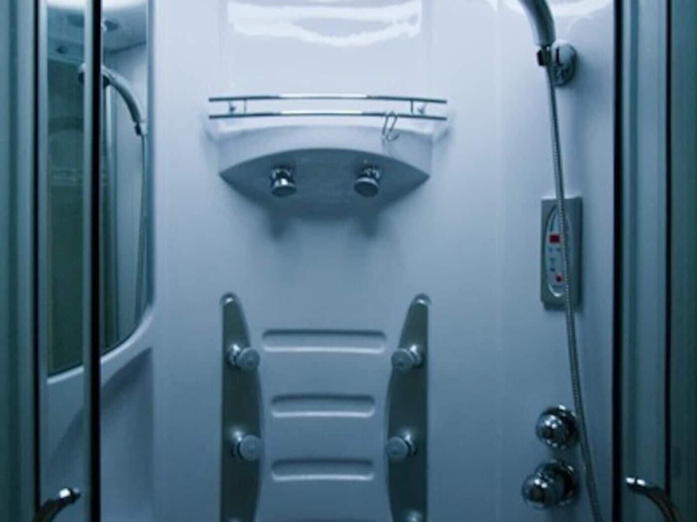 Un baño con ducha, panel de control y toallero.