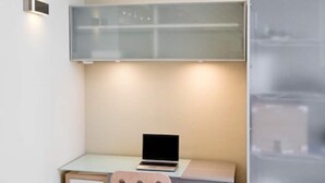 A small, modern room with a desk, a laptop, a chair, and a frosted glass cabinet. - San Sebastián de los Reyes – Loft with 2 Bedrooms (San Sebastián de los Reyes)