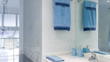 Un bagno con doccia, lavandino e specchio.