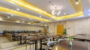 A hotel dining area with multiple tables and chairs, a chandelier, and a clean, modern design. - Vienna International Hotel (Shanghai)
