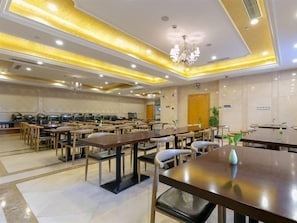 A hotel dining area with multiple tables and chairs, a chandelier, and a clean, modern design. - Vienna International Hotel (Shanghai)